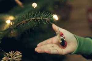 christmas decoration hanging on a tree held by a hand