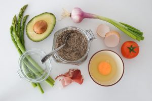 Cooking prep ingredients with asparagus, avocados, pepper, shallots, eggs, and tomatos